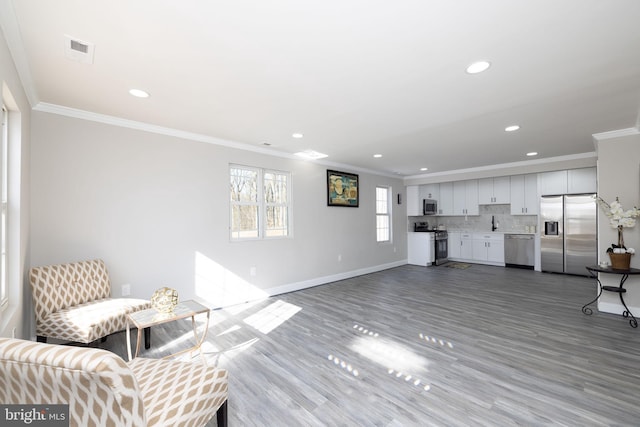 living room featuring crown molding and light hardwood / wood-style flooring