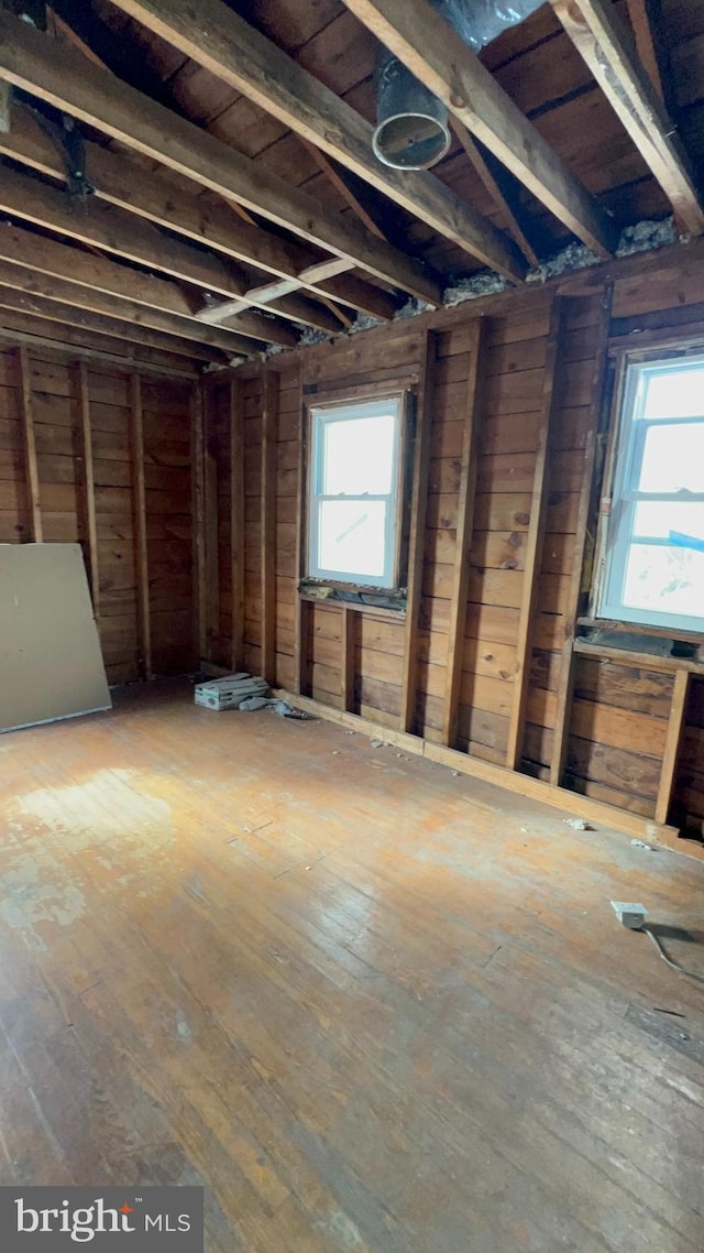 miscellaneous room with wood-type flooring and wooden walls