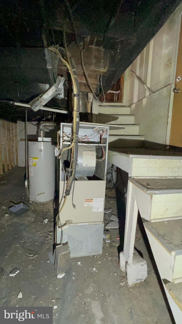 utility room featuring heating unit and water heater