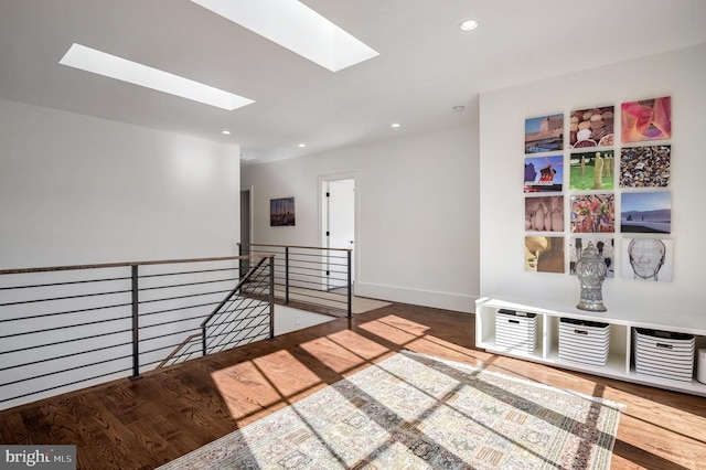 sitting room with hardwood / wood-style flooring and a skylight