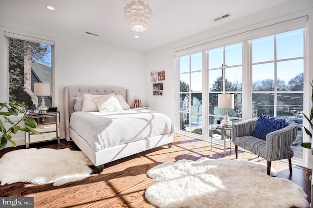 bedroom with multiple windows and wood-type flooring