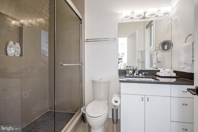 bathroom featuring a shower with door, vanity, and toilet