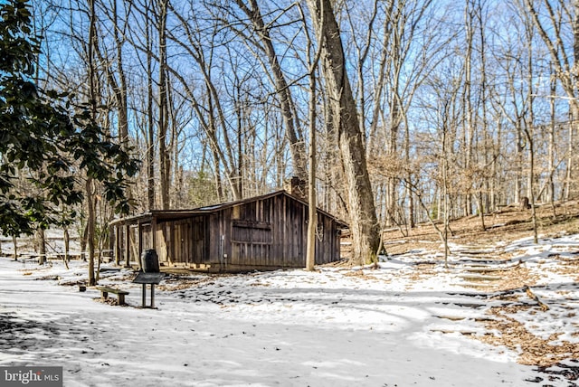 snow covered property with an outdoor structure