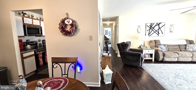 living room with dark hardwood / wood-style flooring and ceiling fan