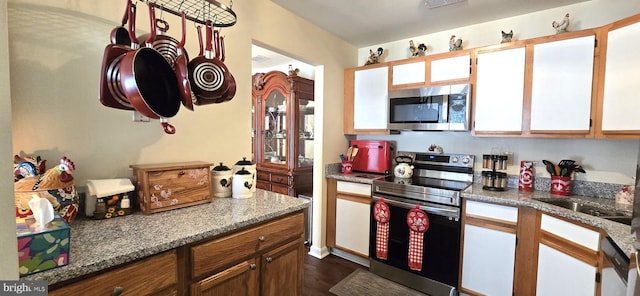 kitchen with light stone counters, white cabinets, and appliances with stainless steel finishes