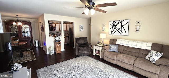 living room with ceiling fan with notable chandelier and dark hardwood / wood-style floors