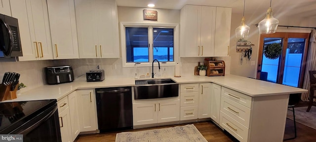 kitchen featuring black appliances, sink, white cabinets, hanging light fixtures, and kitchen peninsula