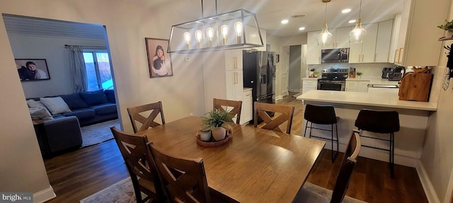 dining area featuring dark wood-type flooring and sink