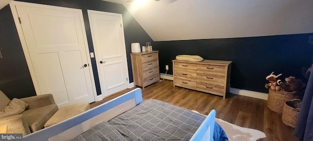 bedroom featuring lofted ceiling, dark hardwood / wood-style flooring, and a baseboard heating unit