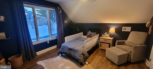 bedroom with lofted ceiling and hardwood / wood-style floors