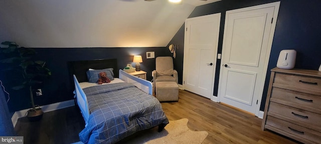 bedroom featuring hardwood / wood-style flooring, vaulted ceiling, and ceiling fan