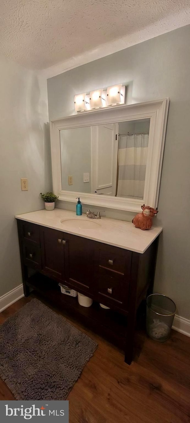 bathroom featuring vanity, hardwood / wood-style floors, and a textured ceiling