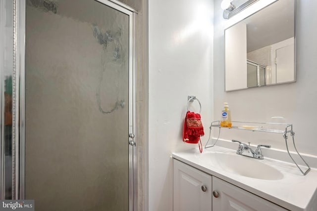 bathroom featuring vanity and a shower with door