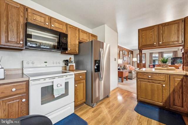 kitchen with stainless steel fridge with ice dispenser, light hardwood / wood-style floors, and white range with electric stovetop