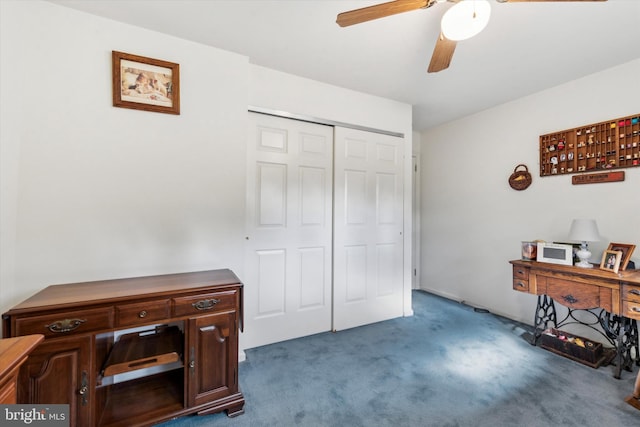 office area with ceiling fan and dark carpet