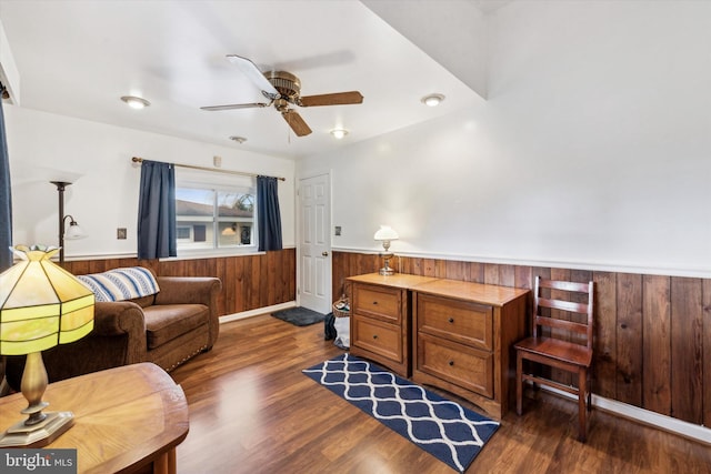 office space with ceiling fan, dark hardwood / wood-style flooring, and wood walls