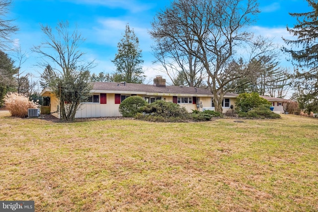 ranch-style home with cooling unit and a front lawn