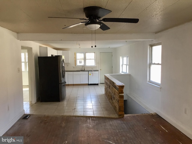 kitchen with sink, light hardwood / wood-style flooring, stainless steel refrigerator, white dishwasher, and white cabinets