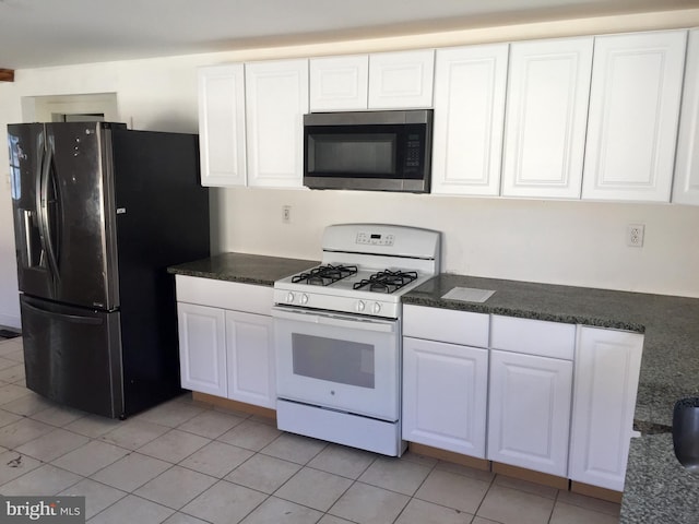 kitchen with white cabinetry, black fridge, white range with gas cooktop, and light tile patterned flooring