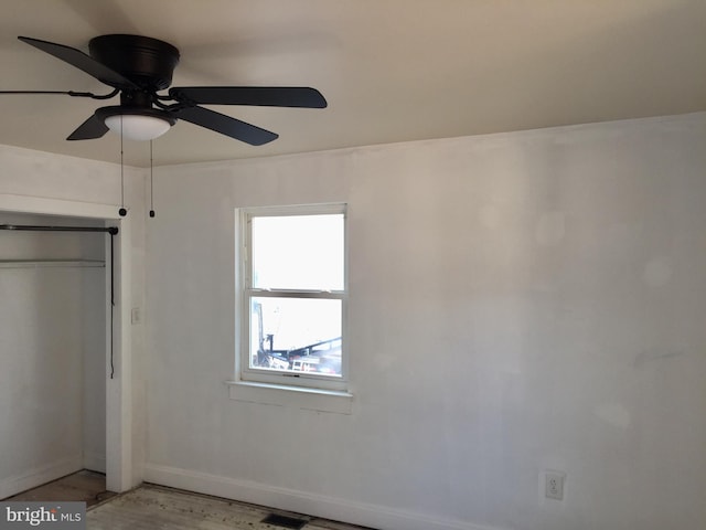 unfurnished bedroom with hardwood / wood-style floors, ceiling fan, and a closet