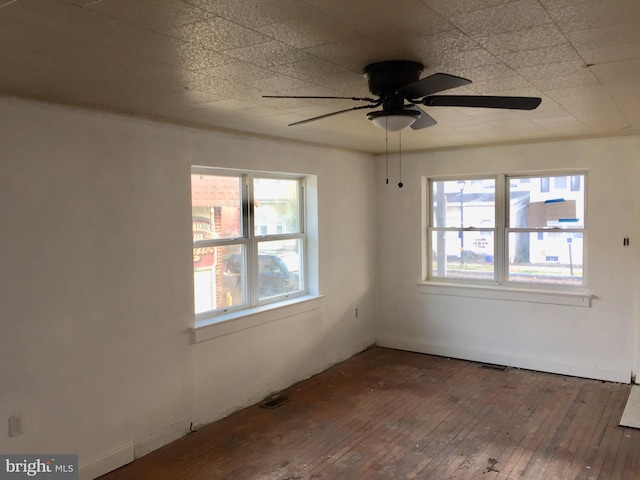 spare room featuring hardwood / wood-style flooring, a healthy amount of sunlight, and ceiling fan