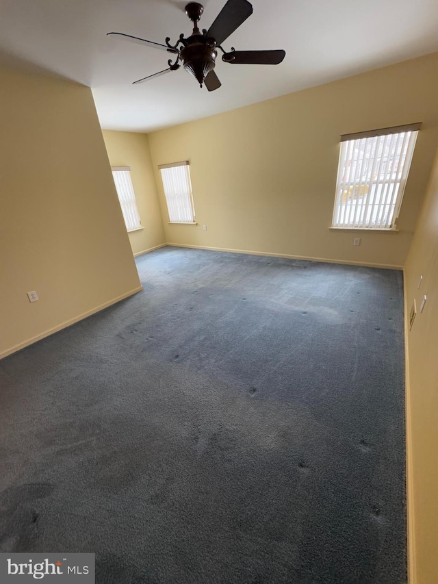 carpeted spare room with ceiling fan