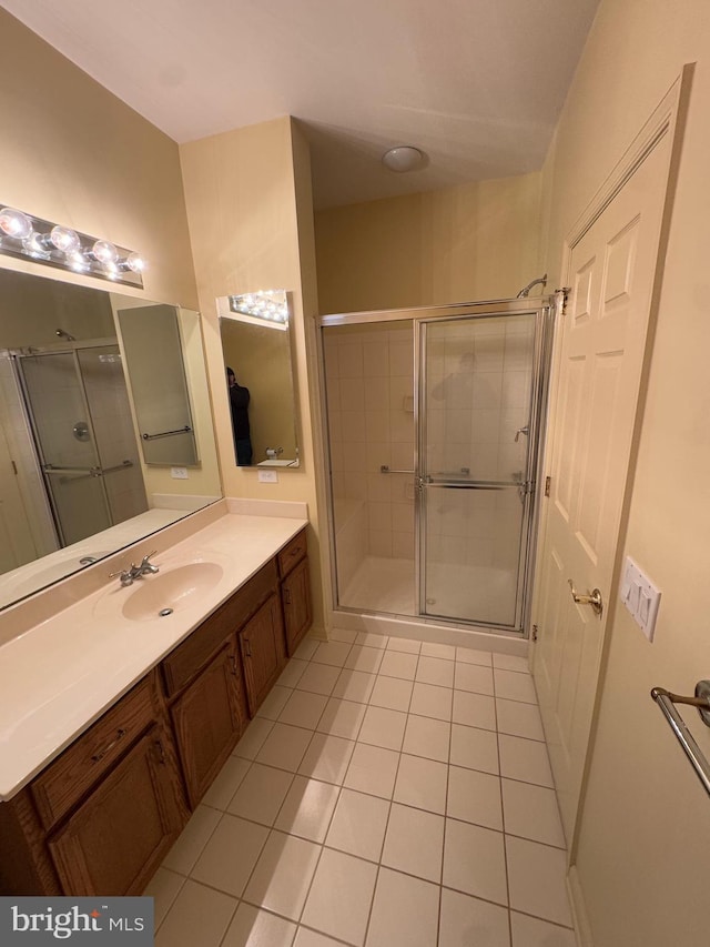 bathroom with tile patterned floors, a shower with shower door, and vanity