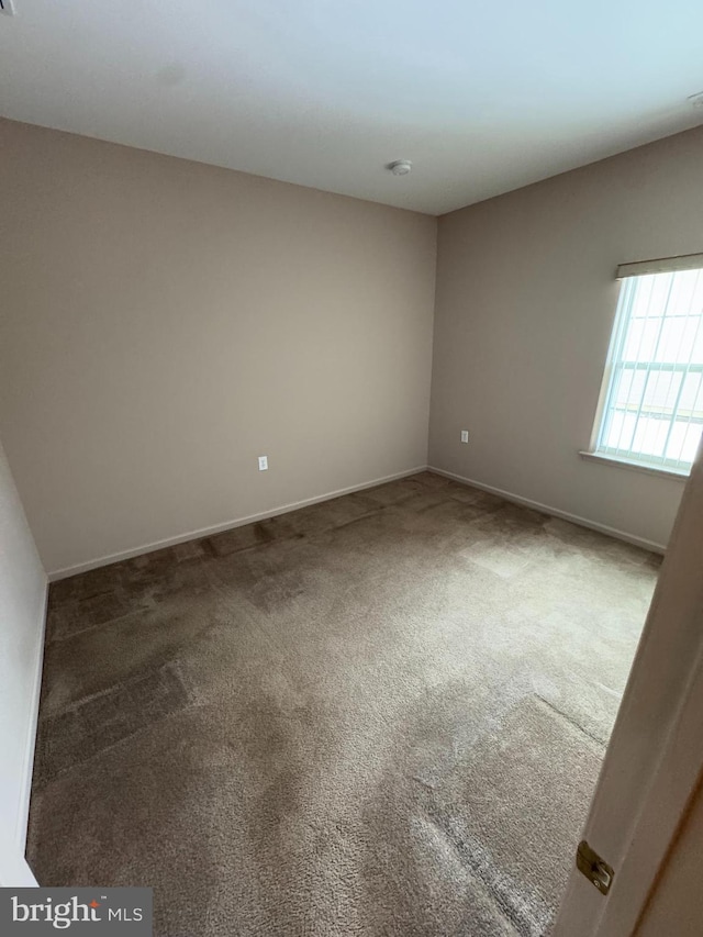 unfurnished room with dark carpet