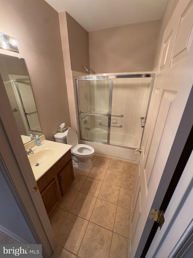 full bathroom with vanity, tile patterned floors, shower / bath combination with glass door, and toilet