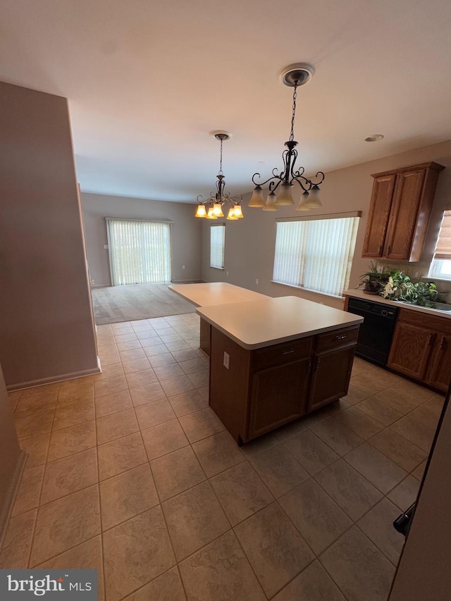 kitchen with a center island, decorative light fixtures, black dishwasher, and tile patterned flooring