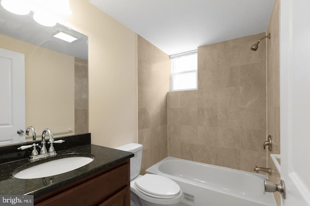 full bathroom with tiled shower / bath combo, vanity, and toilet