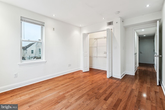 unfurnished bedroom featuring hardwood / wood-style flooring and a closet