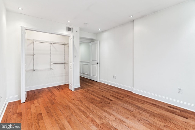 unfurnished bedroom with hardwood / wood-style flooring and a closet