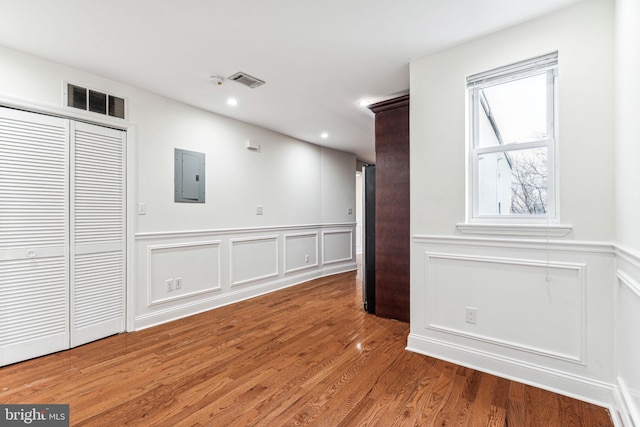 spare room featuring hardwood / wood-style flooring and electric panel