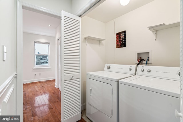 laundry area featuring hardwood / wood-style flooring and washing machine and clothes dryer