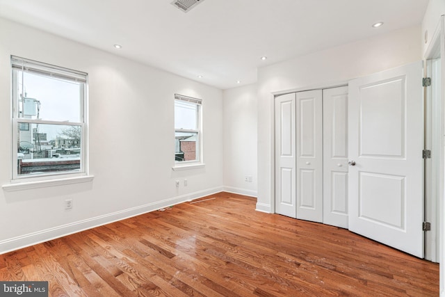 unfurnished bedroom with light hardwood / wood-style floors and a closet