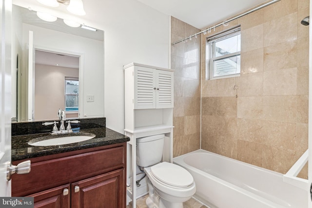 full bathroom featuring tiled shower / bath combo, vanity, and toilet