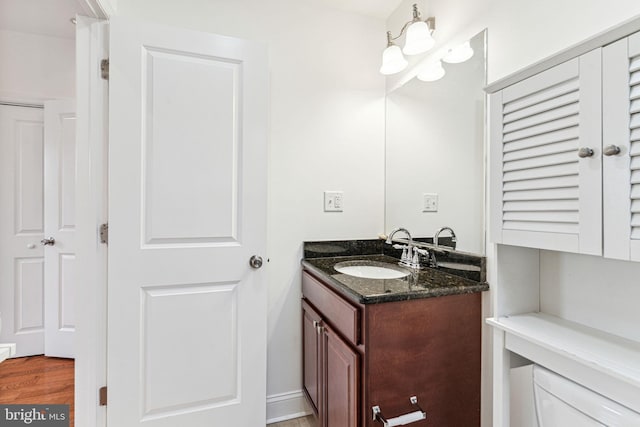 bathroom featuring vanity, toilet, wood-type flooring, and a notable chandelier