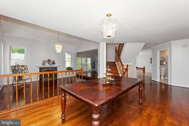 dining space with lofted ceiling, wood-type flooring, and a chandelier