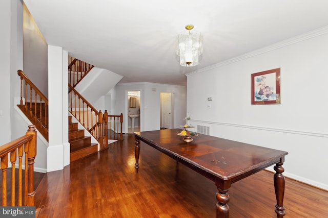 dining space with a notable chandelier, ornamental molding, and dark hardwood / wood-style floors