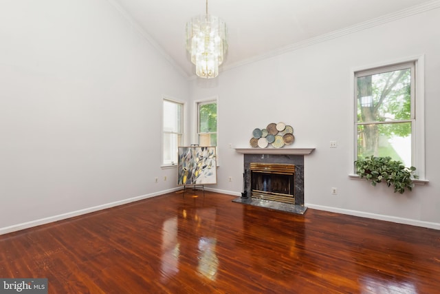 unfurnished living room with crown molding, an inviting chandelier, high vaulted ceiling, hardwood / wood-style flooring, and a high end fireplace