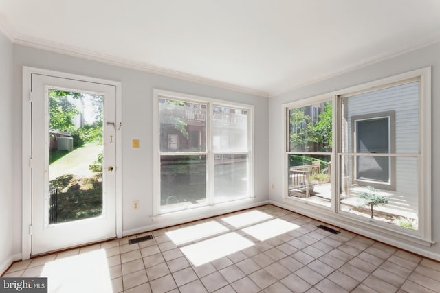 doorway to outside with crown molding and light tile patterned flooring