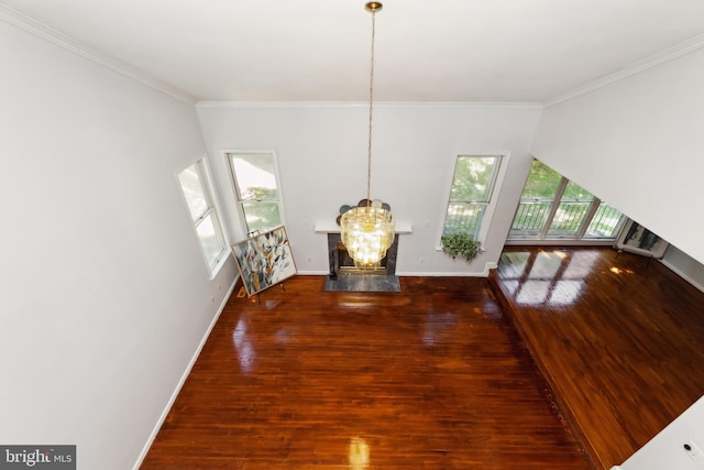 dining room featuring dark hardwood / wood-style flooring, plenty of natural light, ornamental molding, and an inviting chandelier