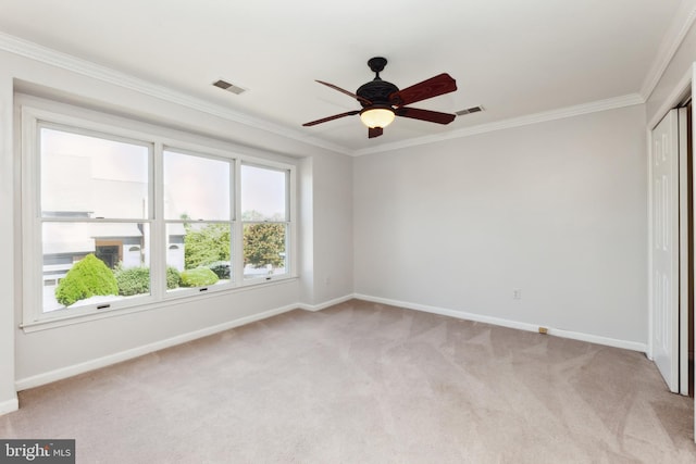 unfurnished bedroom with ornamental molding, light carpet, and ceiling fan