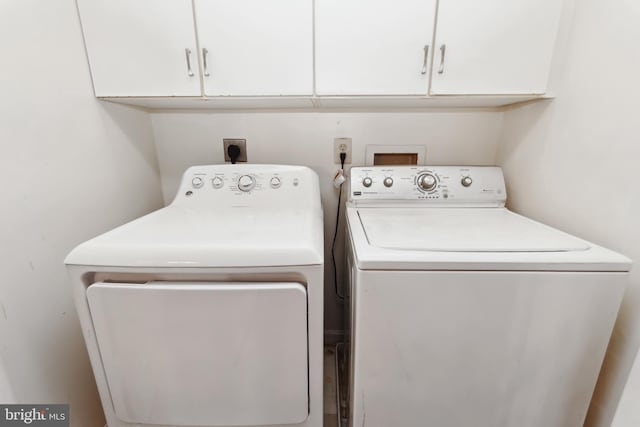 laundry room with cabinets and washer and clothes dryer