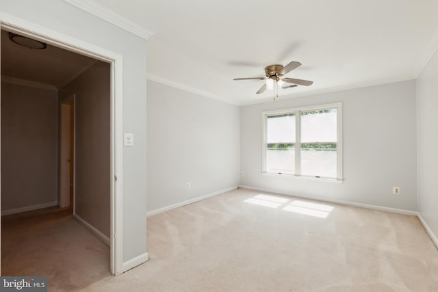 empty room featuring ornamental molding, light colored carpet, and ceiling fan