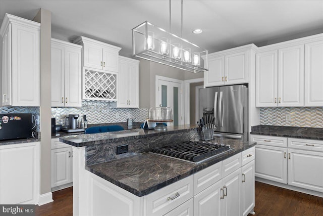 kitchen featuring dark hardwood / wood-style flooring, decorative light fixtures, stainless steel appliances, and white cabinets