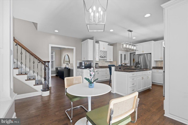 dining area featuring dark wood-type flooring and a chandelier