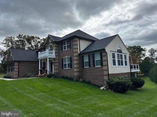 view of front of home featuring a balcony and a front yard