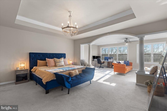 bedroom with a tray ceiling and decorative columns